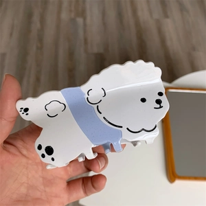 Primer plano de pinza para el pelo de acetato con diseño de perro blanco y azul