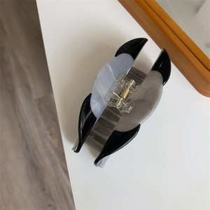 Detail view of the sleek metal spring and marble texture on this puppy hair claw clip