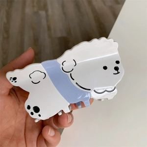 Detalle de la pinza para el pelo con forma de perro de acetato blanco y purpurina brillante