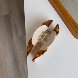 Detail of tortoise shell acetate dog hair claw clip with golden metal spring mechanism