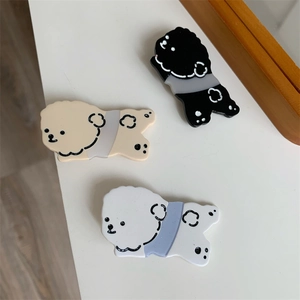 Close-up of three cute acrylic puppy hair clips in black, beige, and white colors