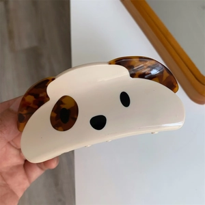 Close-up of acetic acid hair claw clip with a cute squinting dog pattern design