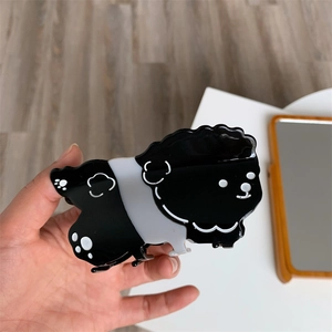Detalle de una linda pinza para el cabello con forma de perro en acetato blanco y negro