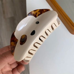 Detailed view of the acetate cream dog hair claw with tortoise shell ear patterns