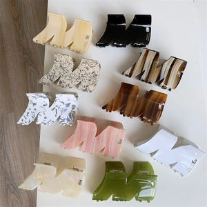 Detail showing various colors of M-shaped acetate hair claws with sparkling rhinestone accents