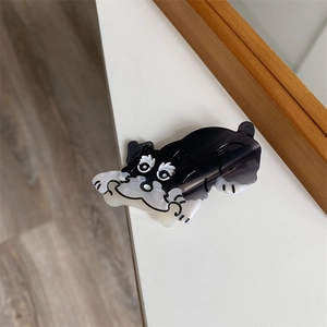 Nahaufnahme einer Haarspange aus Acetat in Schnauzer-Form mit Knochen auf weißem Grund