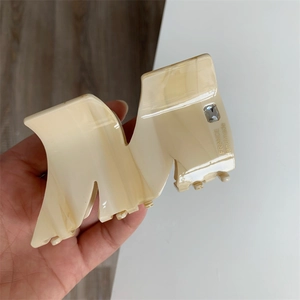 Creamy acetate large hair claw with M-shaped geometric design and rhinestone accent