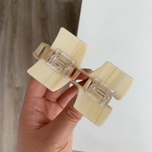 Close-up of a large cream-colored acetate hair claw clip with a square geometric design