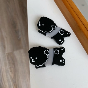 Close-up of two cute cartoon dog hair clips in black and white acrylic material