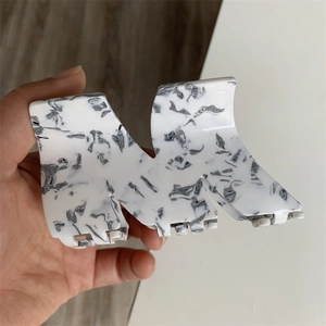 Detail of marble pattern acetate hair claw clip with large geometric design and grip teeth