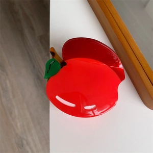 Dettaglio della pinza per capelli a mela rossa in acetato lucido dal design creativo