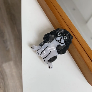 Detailansicht der schwarz-weiß gefleckten Hunde-Haarklammer aus glänzendem Acetat-Material