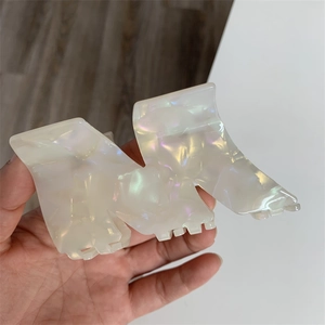 Close-up of pearl white acetic acid M-shaped hair claw clip with shimmering finish