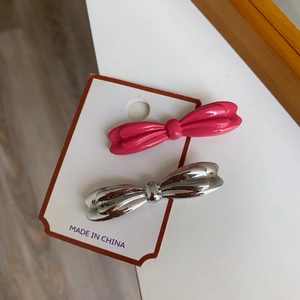 Barrettes à cheveux nœud papillon en métal rose et argent sur carte de produit