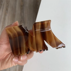 Detailed shot of large amber marble hair claw clip with geometric wavy design