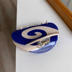 Detail view of the blue and cream acetic acid hair claw clip with spiral pattern