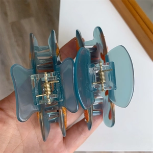 Détail du mécanisme à ressort doré sur les pinces à cheveux poisson en bleu translucide