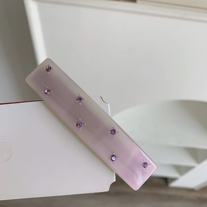 Detailed macro view of a lavender acetate hair clip with eight purple rhinestones