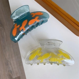 Détail de pinces à cheveux poisson avec texture acrylique et strass brillants