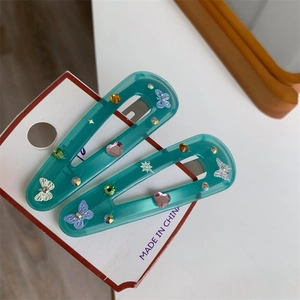 Colorful teal resin butterfly hair clips with pink heart and rhinestone accents