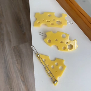 Gros plan de barrettes à cheveux créatives en forme de fromage suisse jaune