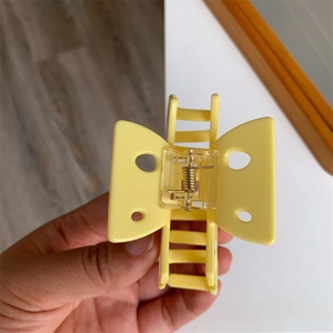 Détail de la pince à cheveux papillon jaune avec ressort solide et dents de prise
