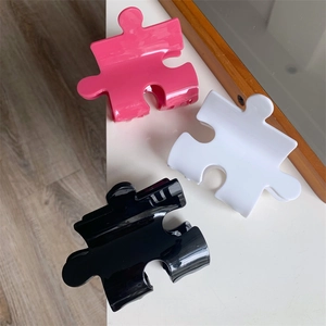 Colorful creative puzzle piece hair claws in pink, white, and black acetate finish