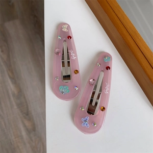 Detail of pink resin butterfly hair clips with colorful rhinestones and silver metal base