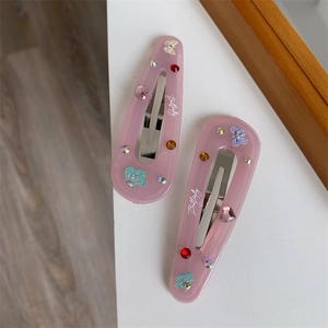 Close-up of pink resin butterfly hair clips with colorful rhinestones and Butterfly text
