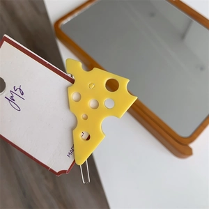Détail macro d'une pince à cheveux fromage jaune avec trous réalistes sur carte support
