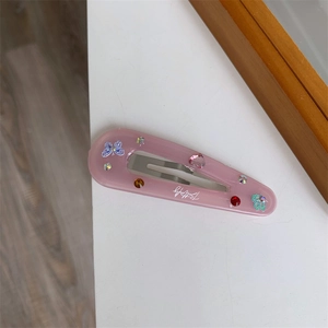 Detail of pink resin butterfly hair clip with colorful rhinestones and metal duckbill base