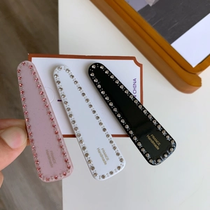Lot de trois barrettes géométriques en acétate avec strass et étiquettes dorées
