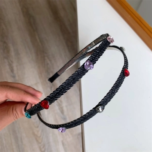 Detail of French vintage headband with colorful heart rhinestones on denim fabric texture