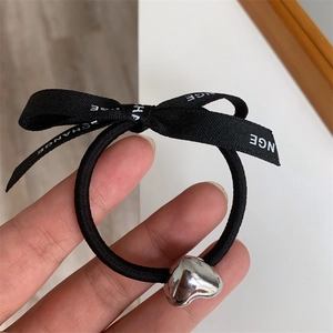Elegant black bow hair tie with silver heart pendant and white CHANGE lettering print