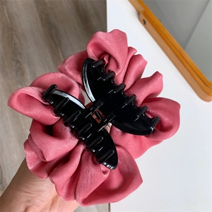 Détail de la grande pince à cheveux en satin rose avec sa structure interne visible