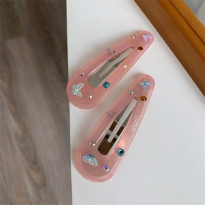 Close-up of pink butterfly hair clips with sparkling rhinestones and glitter resin detail