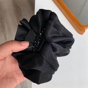 Détail de la grande pince à cheveux en satin noir avec texture plissée effet nuage