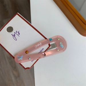 Close-up of pink butterfly hair clip with rhinestones and Butterfly print on display card