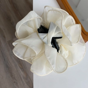Detailed view of cream organza floral hair claw clip with delicate mesh layers