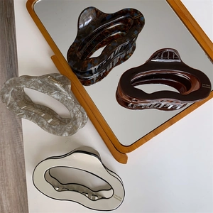Detailed macro view of four marble patterned acetate hair claws on a mirror tray