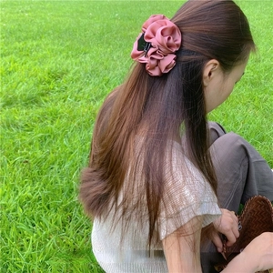 Pince à cheveux fleur en satin rose pour femme dans un cadre naturel extérieur