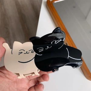 Detail of cute black and white cartoon double cat hair claw clip made of acetate fiber