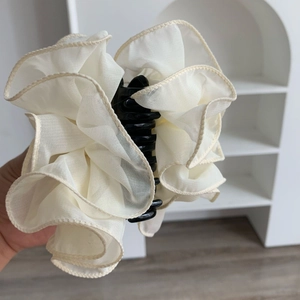 Detail of elegant cream chiffon flower hair claw clip with pleated mesh fabric petals