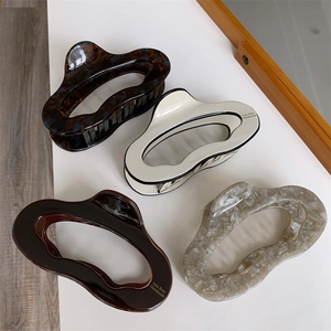 Detail showing four assorted acetate hair claws with shell and marble patterns