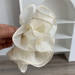 Detail of cream organza oversized hair scrunchie with layered ruffle edge design