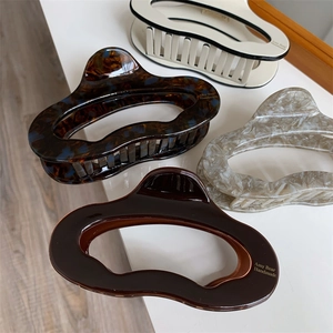 Detail view of four acetate hair claws in tortoise shell and marble patterns