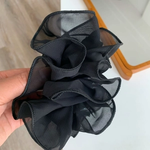 Detail of black organza hair scrunchie with layered mesh ruffles and soft texture