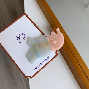 Detail of two-piece cat-shaped hair clips in pastel blue and pink marble resin