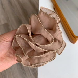 Close-up of elegant ruffles on a mauve organza flower hair claw clip accessory