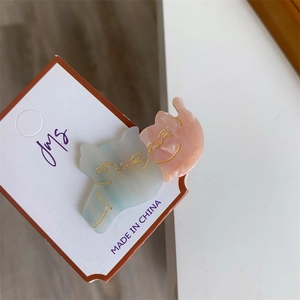 Pair of cute cat-shaped hair clips in pink and blue marble-textured acetate with gold wave patterns